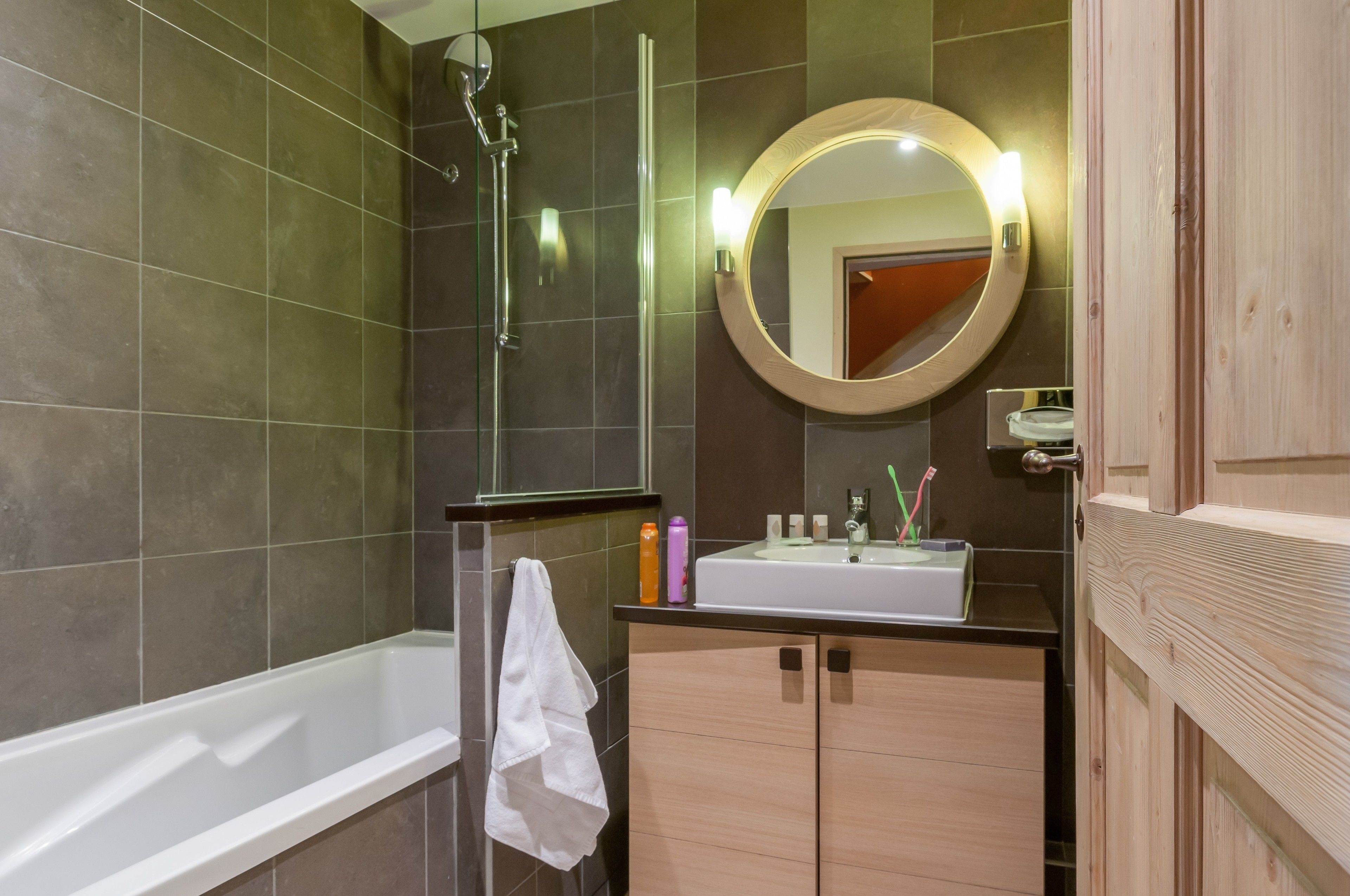A modern bathroom with a bathtub, a shower, and a vanity with a mirror.
