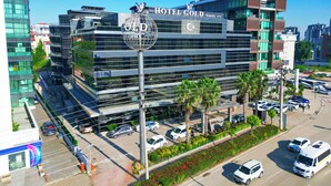 Un hôtel moderne, doté d’une enseigne bien visible, de plusieurs étages et d’un parking où sont stationnées des voitures.