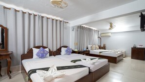 A hotel room with two beds, a wooden headboard, a bedside table, a mirror, and a ceiling fan. - Siem Reap Riverside Hotel (Siem Reap)