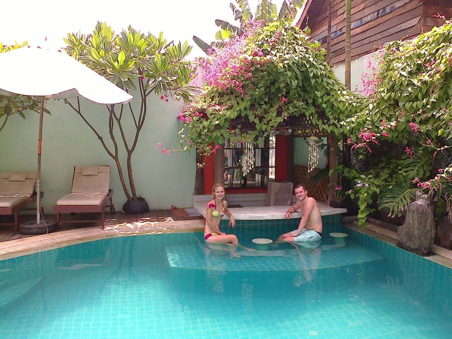 Una piscina al aire libre, sombrillas, sillones reclinables de piscina