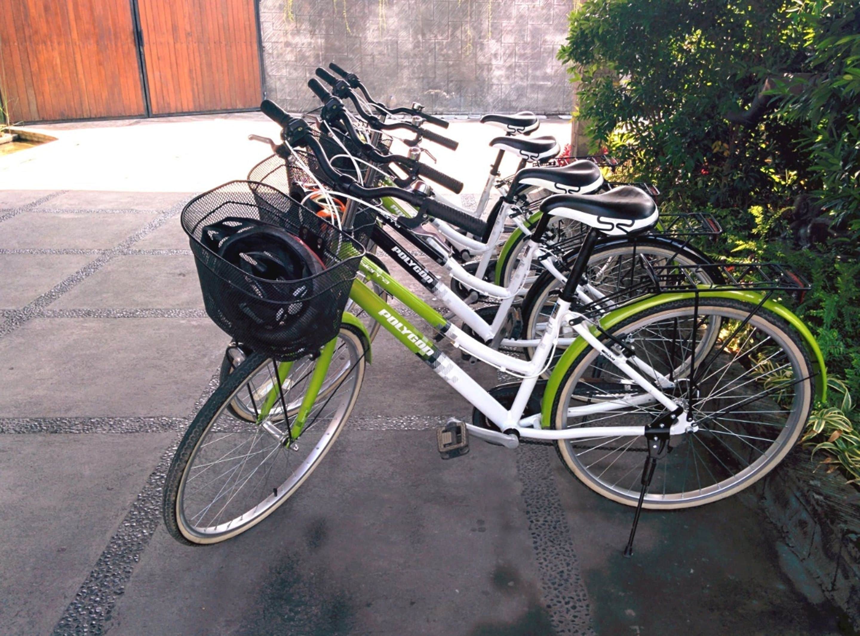 Una bicicleta con una cesta y una botella de agua, estacionada sobre una superficie pavimentada.