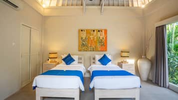 A double room with two beds, a ceiling fan, a large vase, and a painting on the wall.