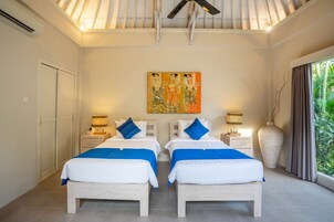 A double room with two beds, a ceiling fan, a large vase, and a painting on the wall.