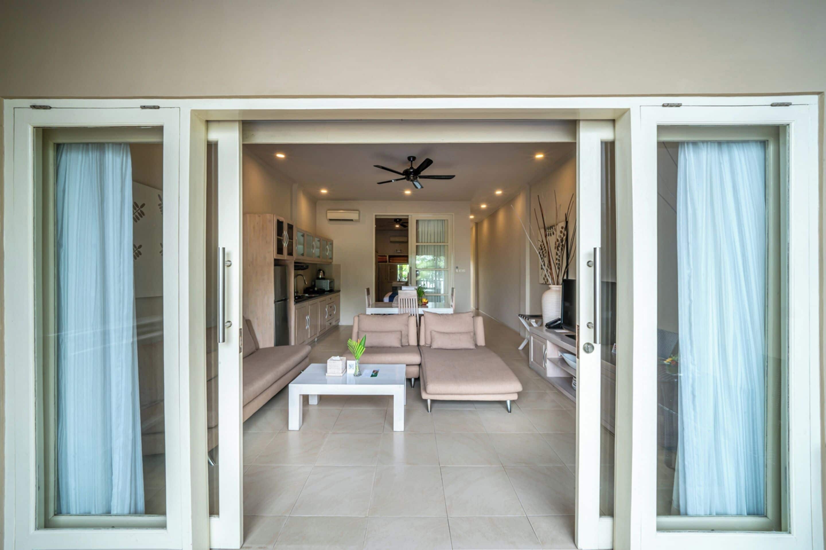 A modern living room with a sectional sofa, a coffee table, and a ceiling fan.
