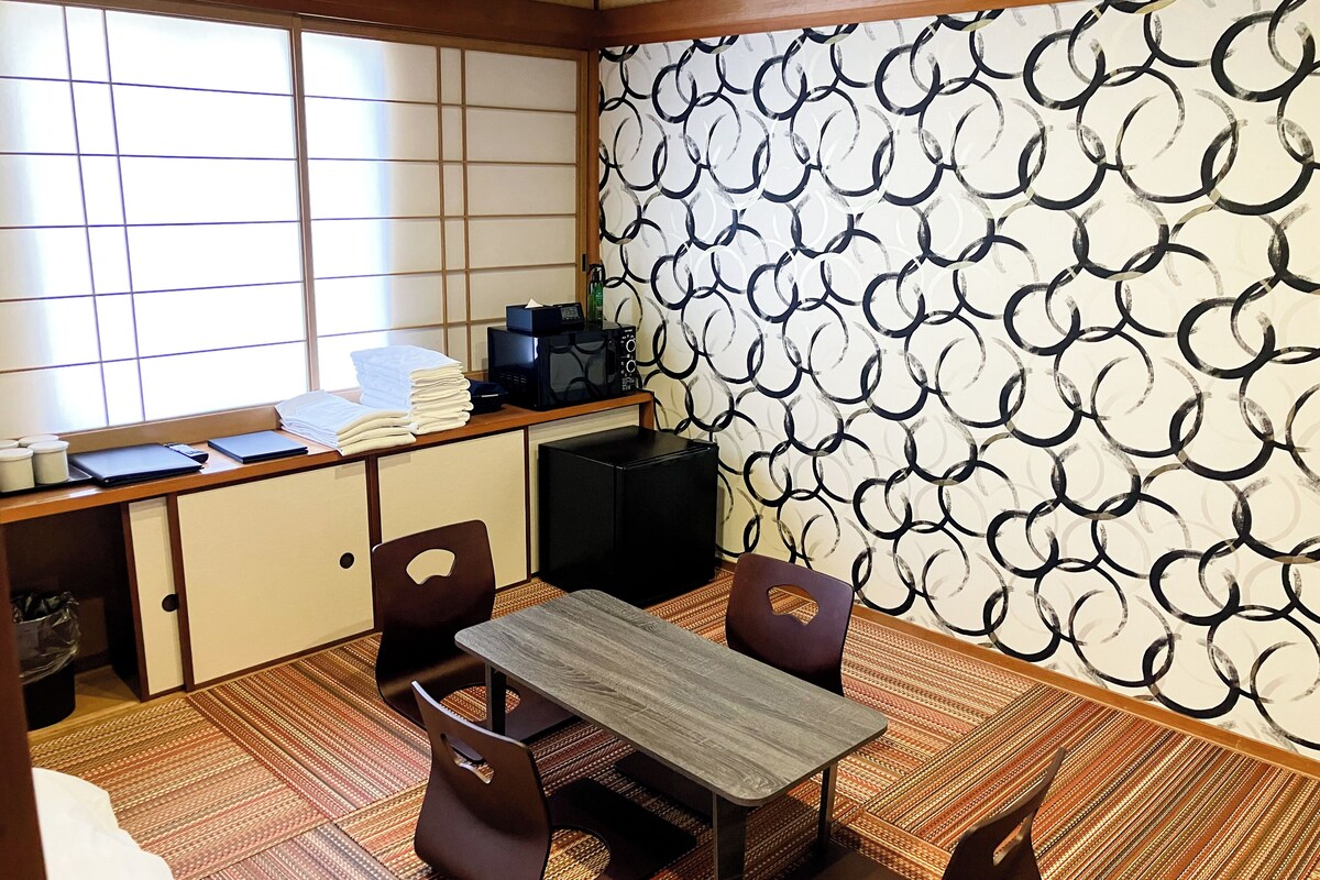A traditional Japanese room with tatami flooring, a low table, and a shoji screen.