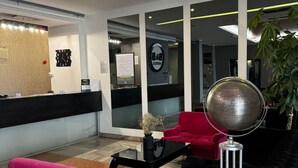 A modern reception area with a reception desk, a clock, and a globe on a stand. -  B&B HOTEL Tychy (Tychy)