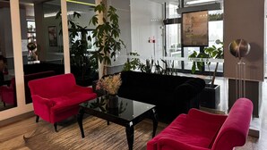 A modern lobby with red sofas, a black sofa, and a glass partition. -  B&B HOTEL Tychy (Tychy)