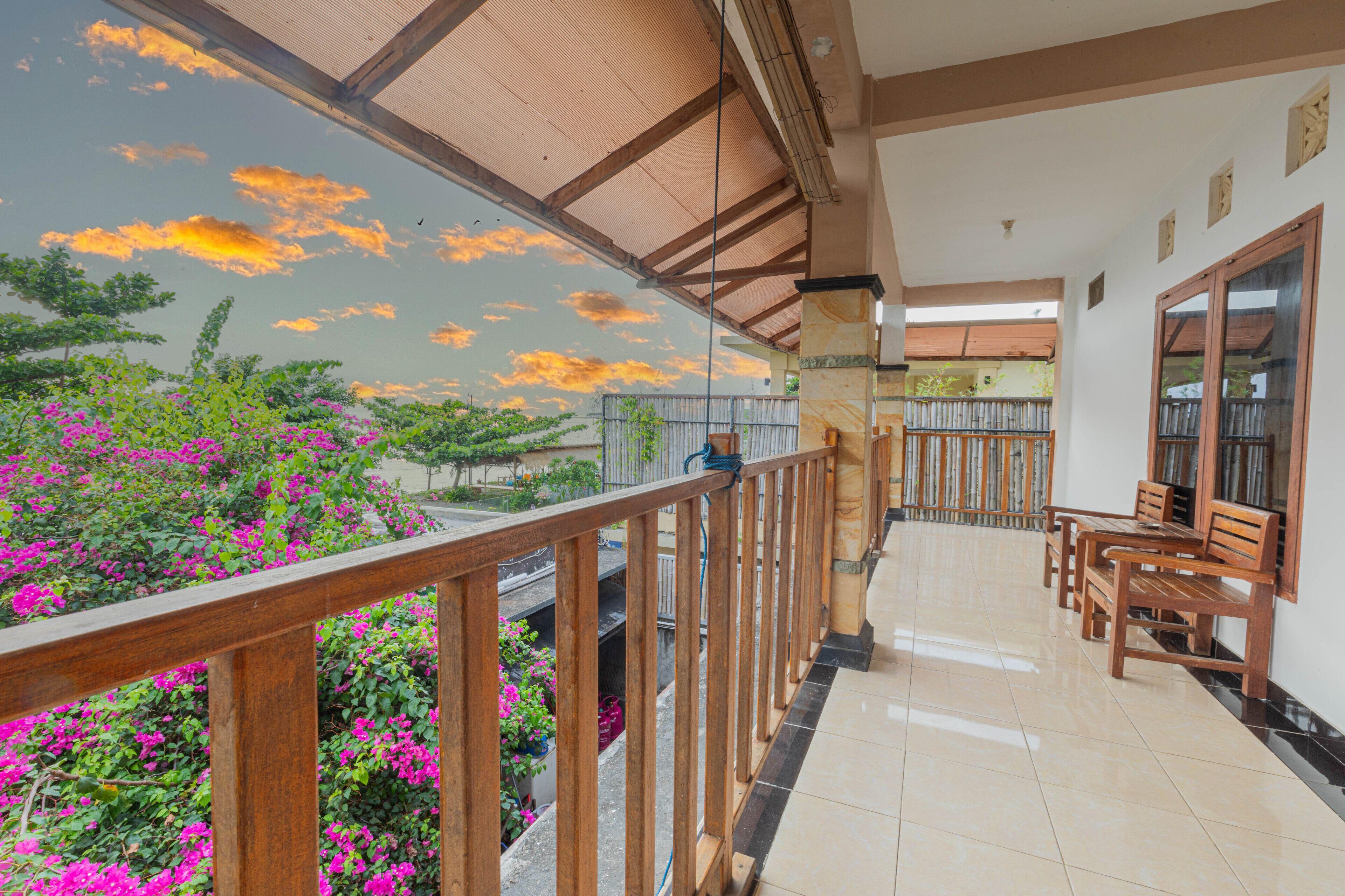 A balcony with wooden railings, a tiled floor, and wooden benches.