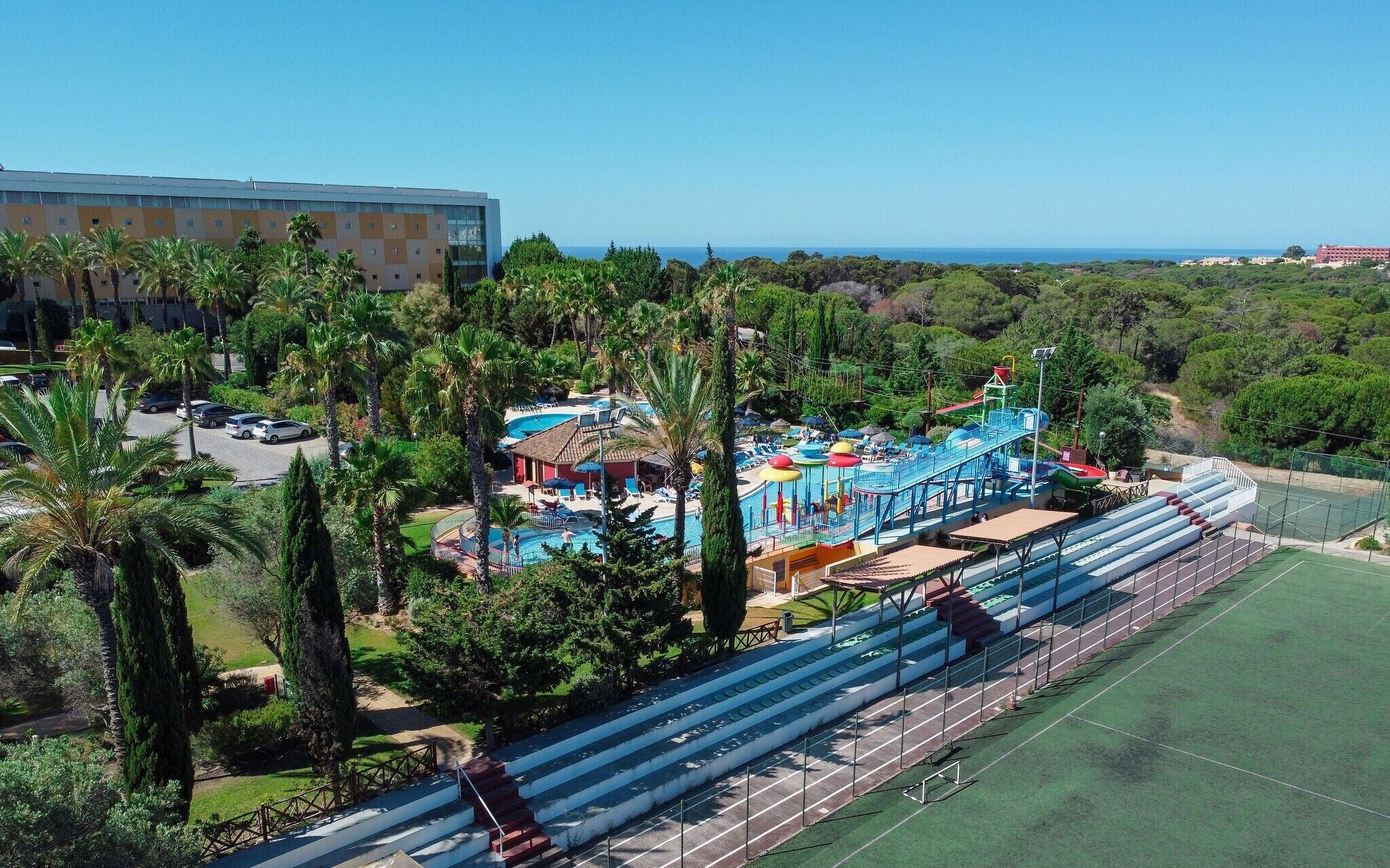 A resort with a swimming pool, a water park, and a tennis court.