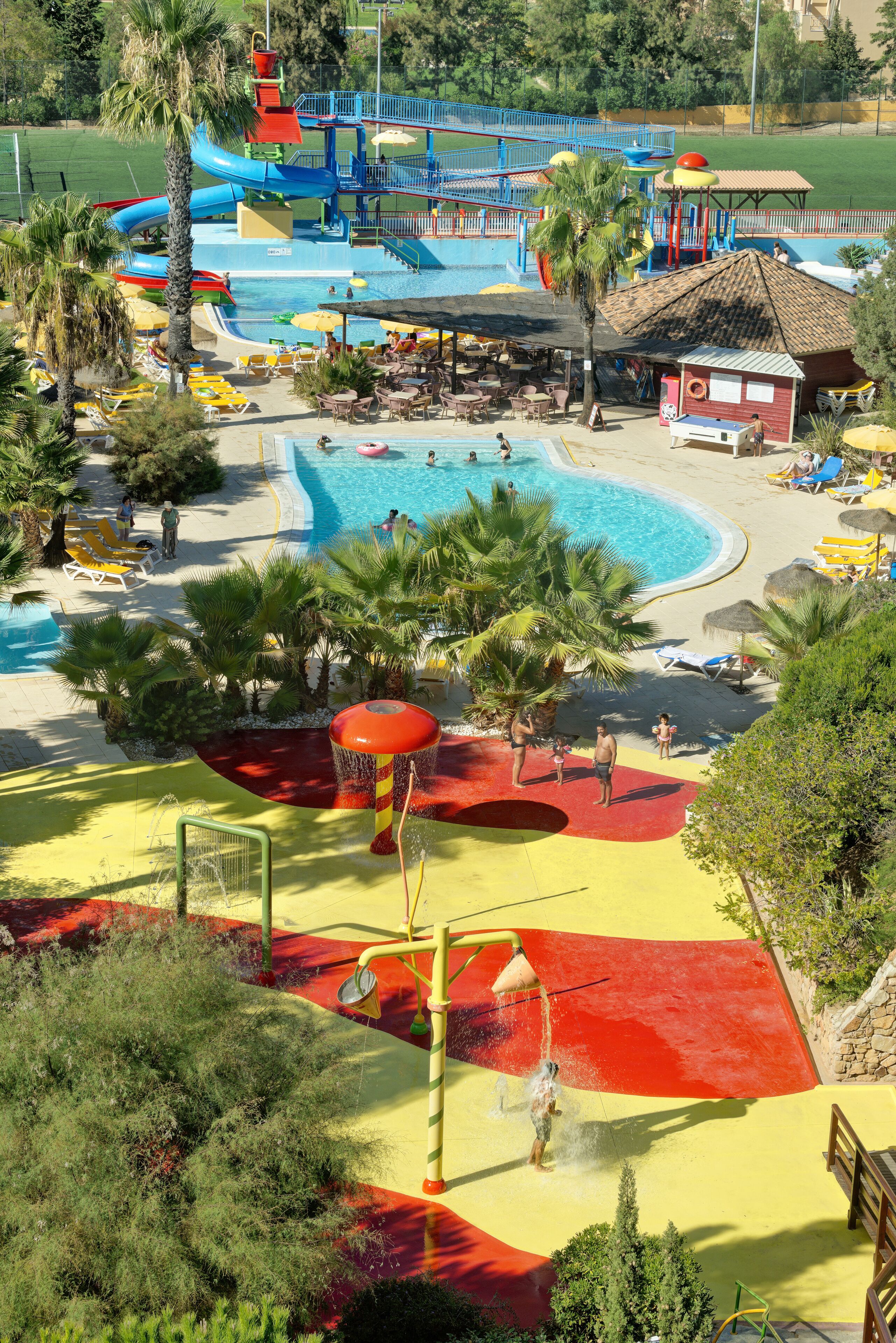 Un parc aquatique avec une piscine, des toboggans et un espace de jeux.