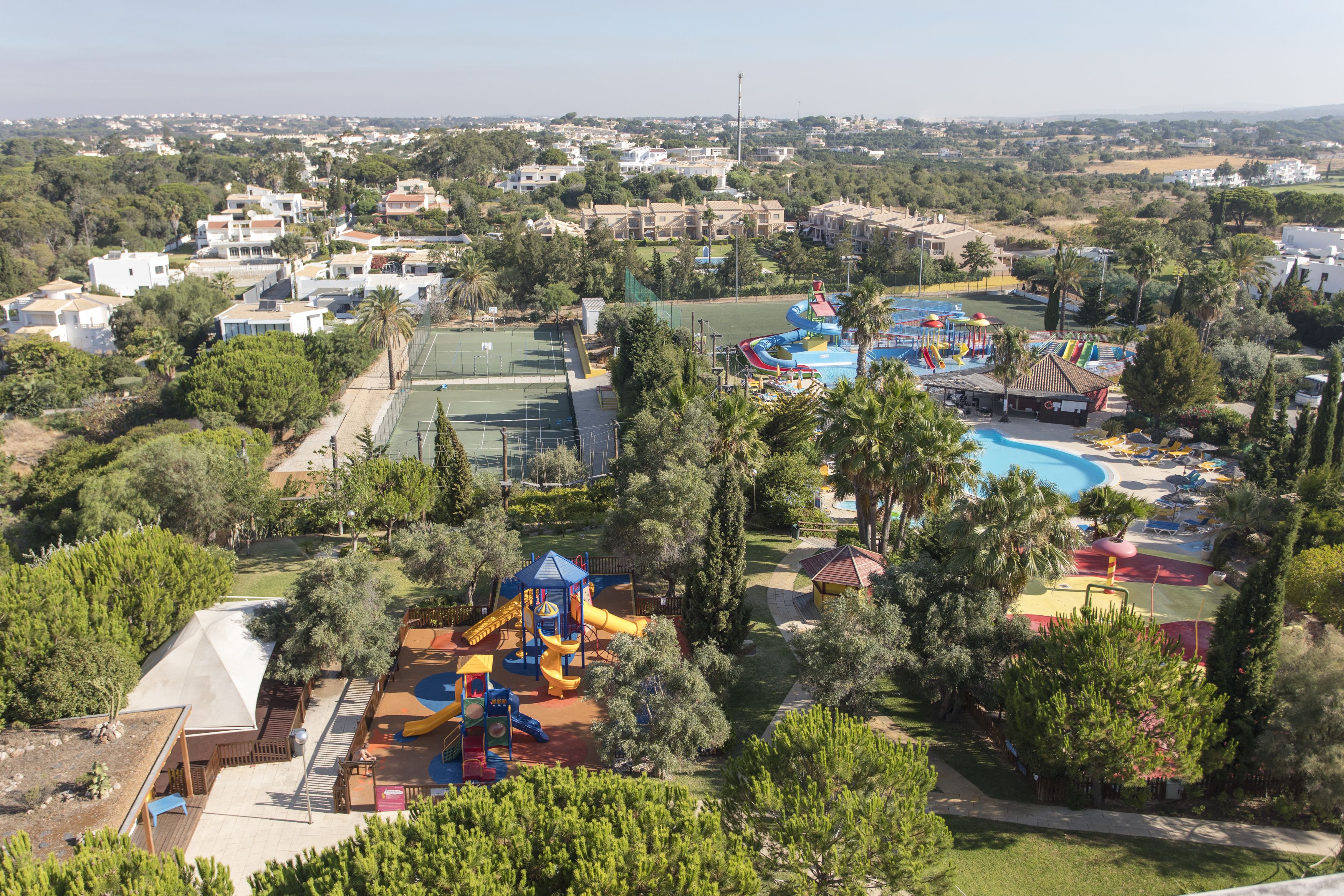 A residential area with a playground, swimming pool, and tennis courts.