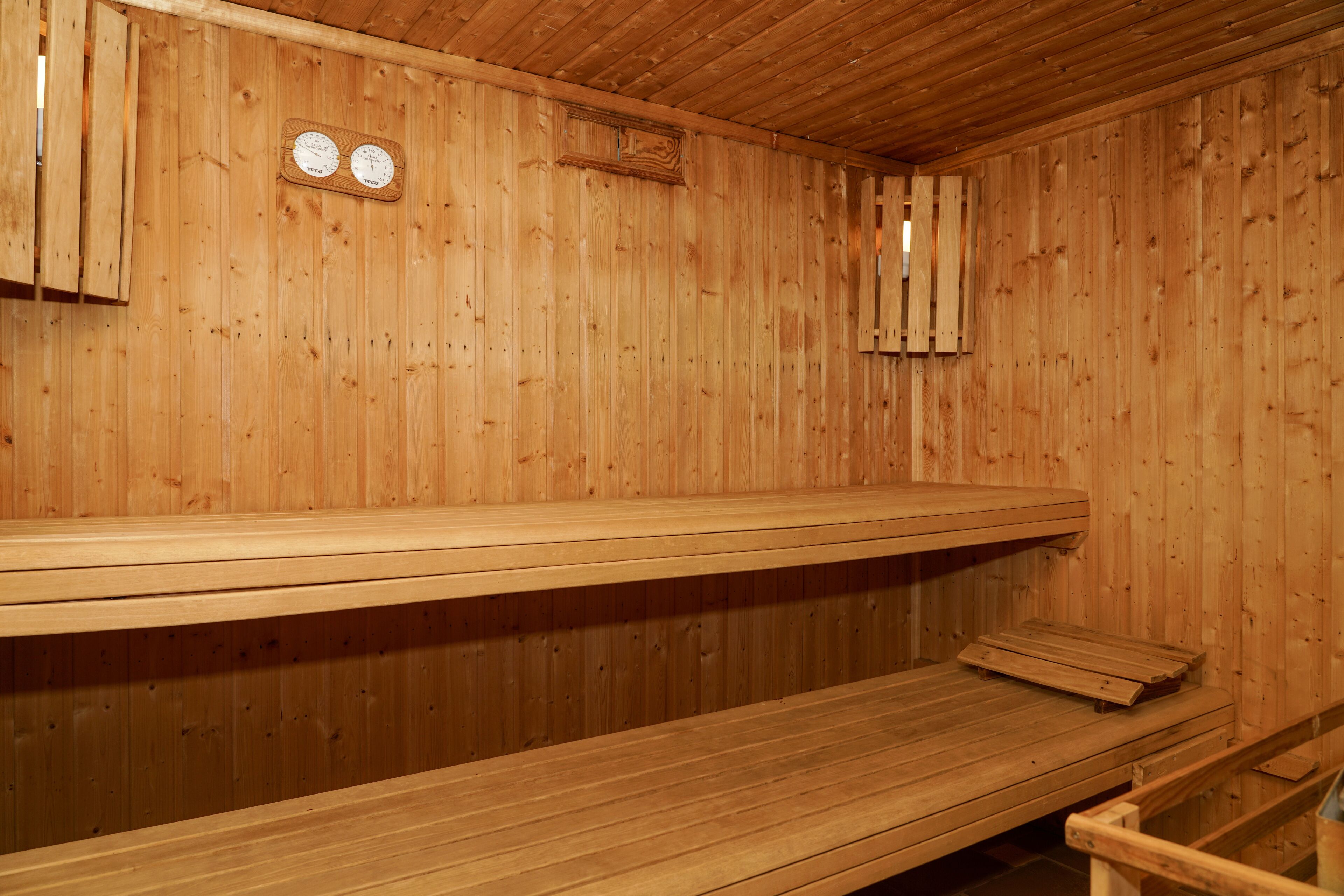 Una sauna de madera con bancos y techo de madera.