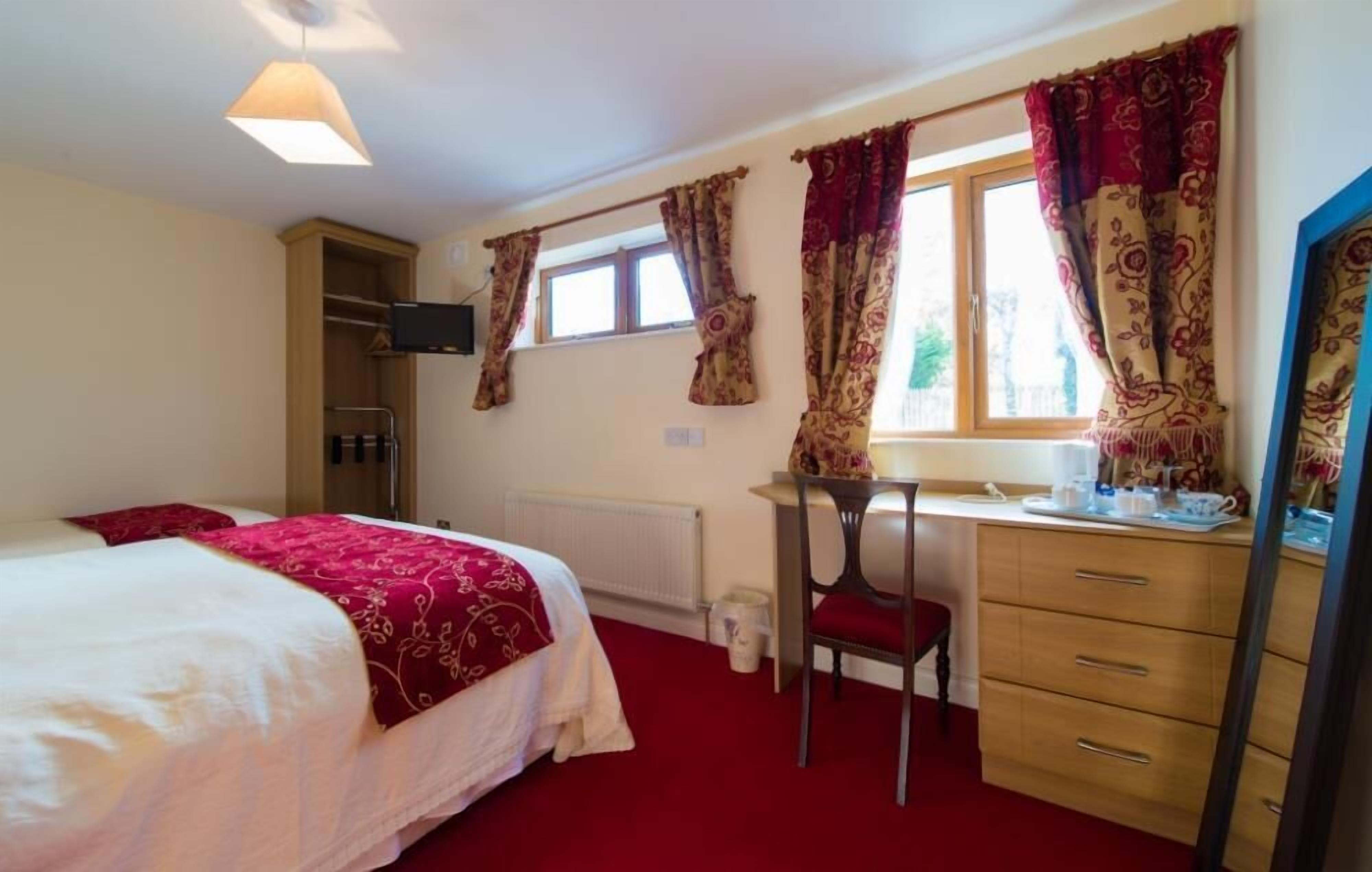 Une chambre à coucher comprenant un lit, un bureau, une chaise et une commode.