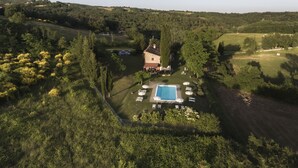 An aerial view of a countryside property with a swimming pool, surrounded by lush greenery and a stone building. - Il Vignolino Bed and Breakfast (Barberino di Mugello)