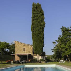 A pool with a stone building and a tall tree in the background. - Il Vignolino Bed and Breakfast (Barberino di Mugello)