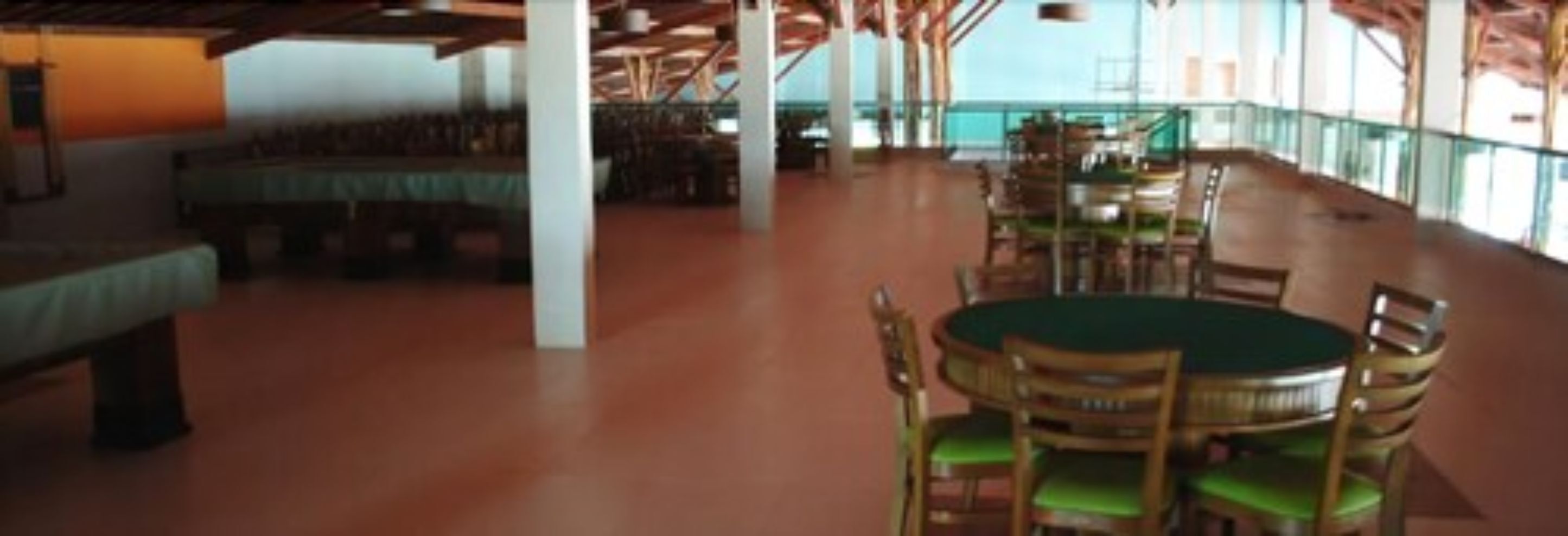 A spacious indoor area with a pool table, multiple seating arrangements, and a view of the outdoors.