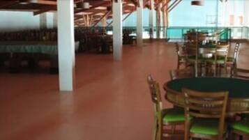 A spacious indoor area with a pool table, multiple seating arrangements, and a view of the outdoors.