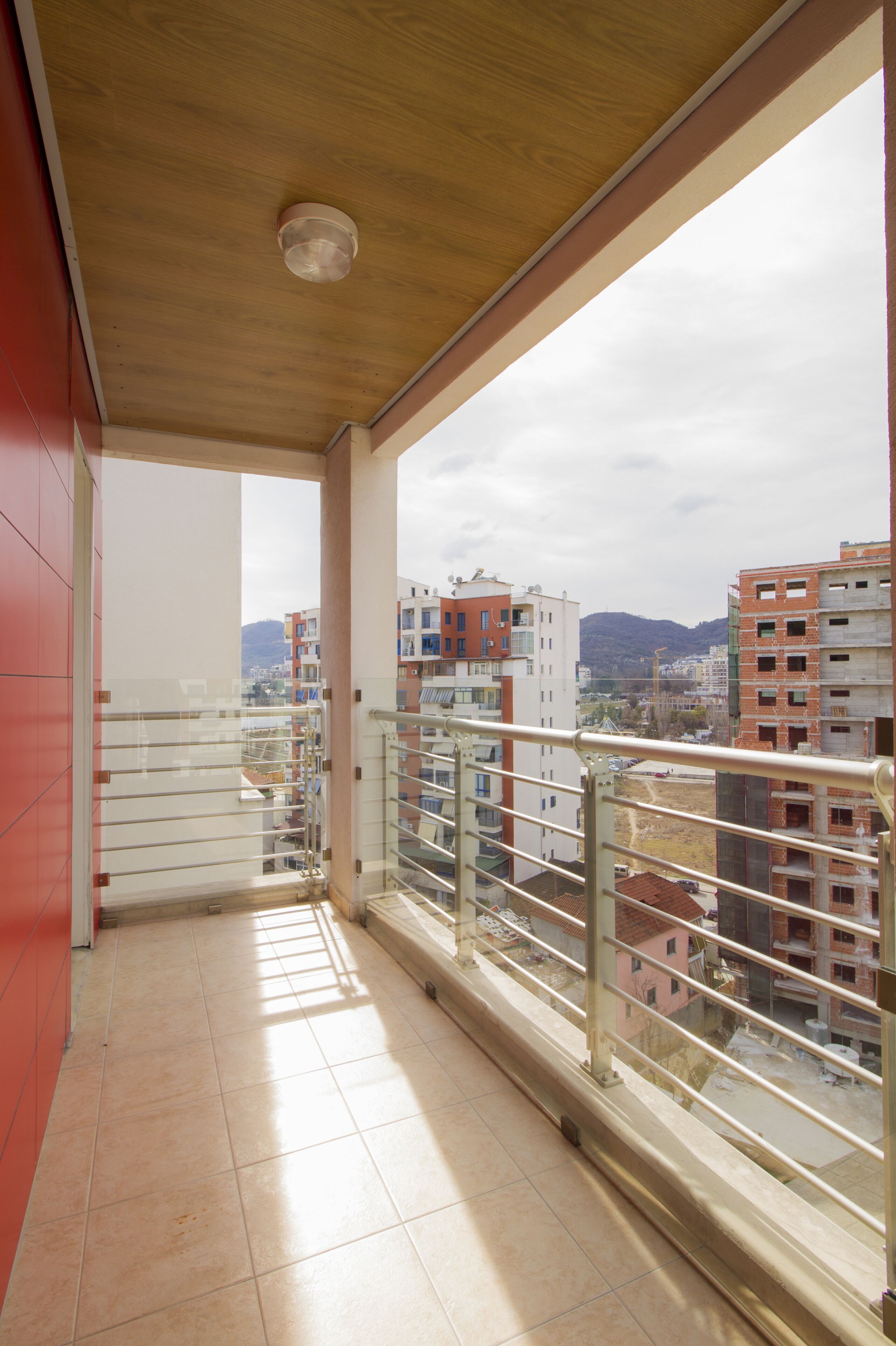Ein Balkon mit Blick auf umliegende Gebäude und ein Berg in der Ferne.