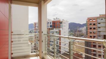 Ein Balkon mit Blick auf umliegende Gebäude und ein Berg in der Ferne.