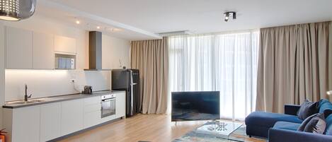 A modern apartment with a kitchen, dining area, and living room.