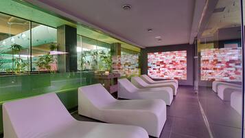 Relax in a serene spa area with lounge chairs and a view of a pool.