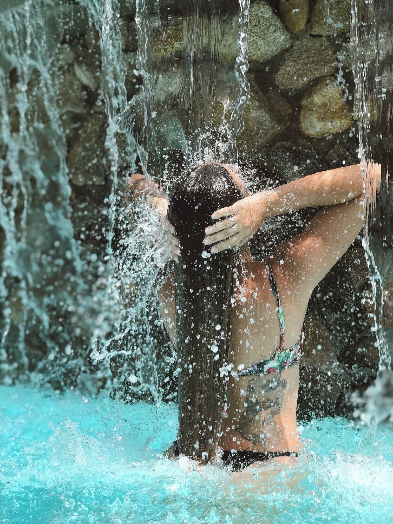 A person in a swimming pool with water splashing around them.