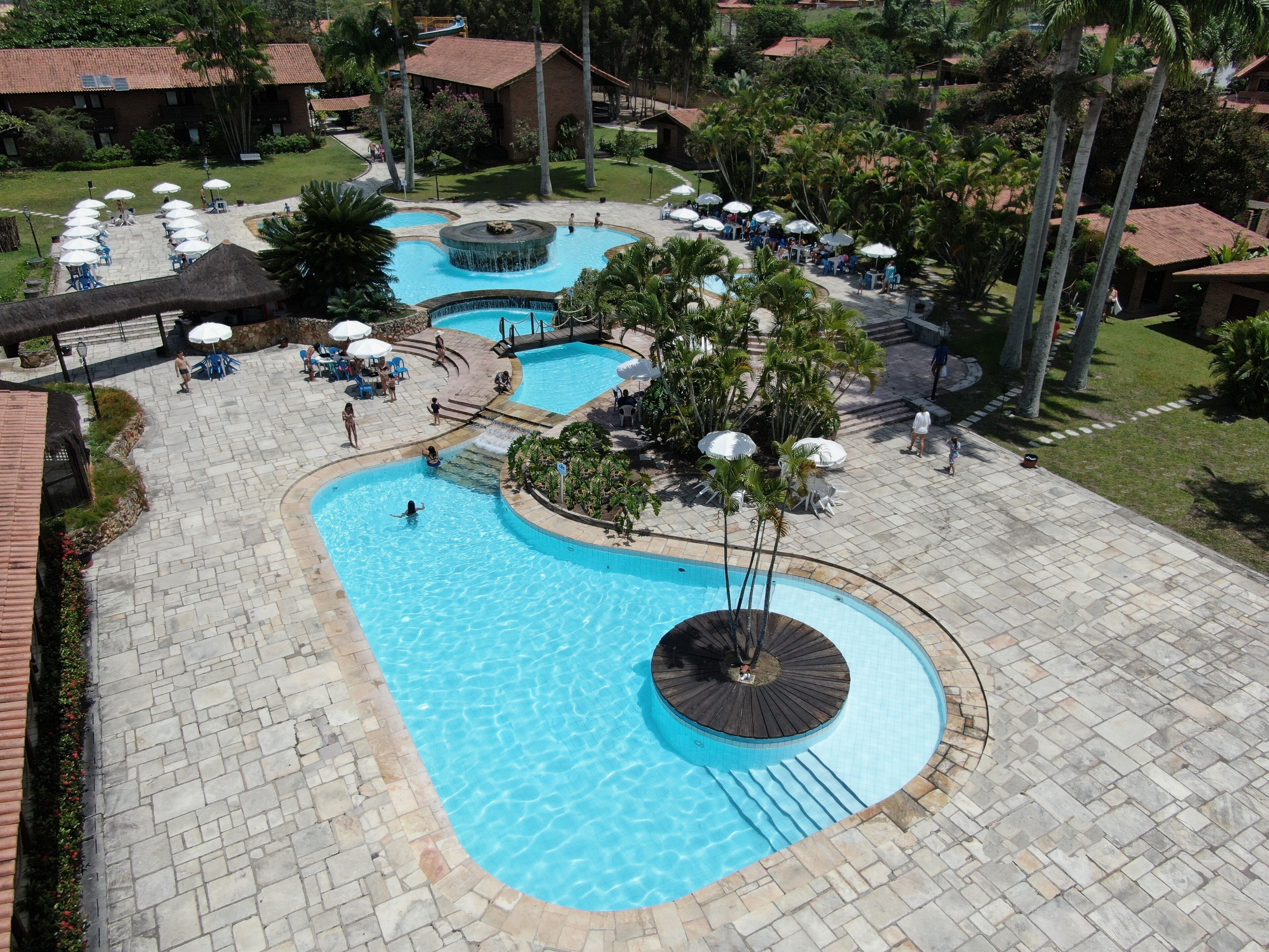 A large outdoor swimming pool with multiple sections and a central water feature.