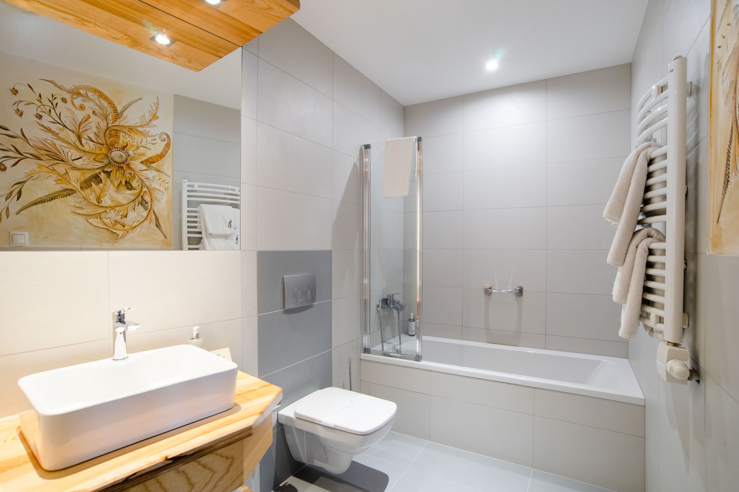 A modern bathroom with a rectangular sink, a toilet, a glass-enclosed shower, and a bathtub.