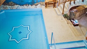 An indoor swimming pool with a star design, wooden stairs, and a mural of a mountainous landscape. - Hotel Sabala (Zakopane)