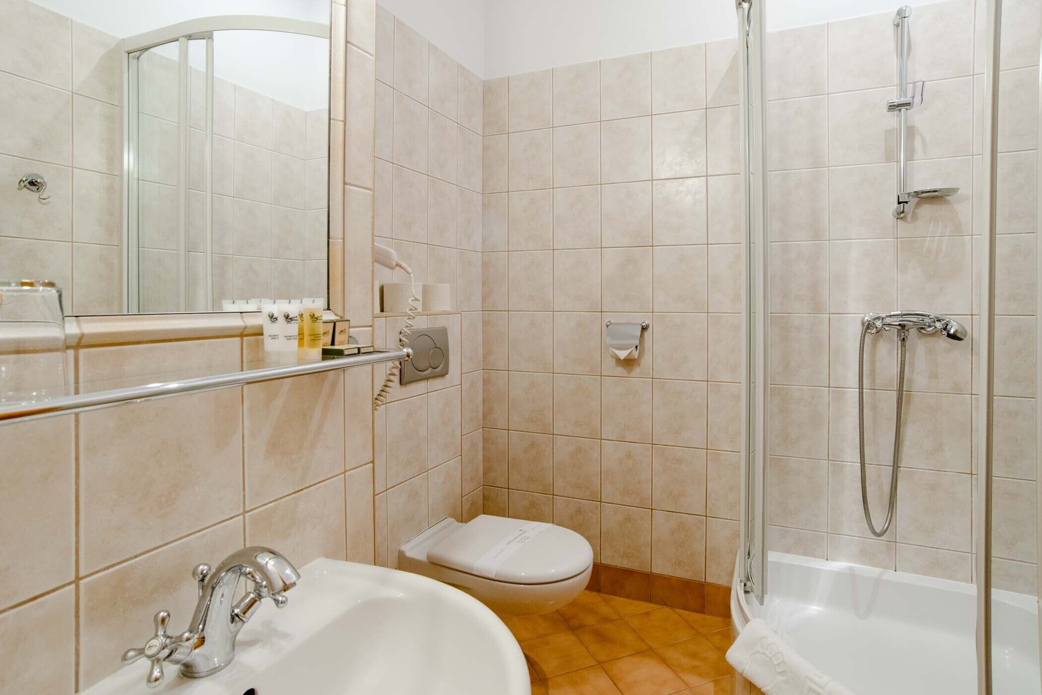 Ein Badezimmer mit Waschbecken, Toilette und Dusche.
