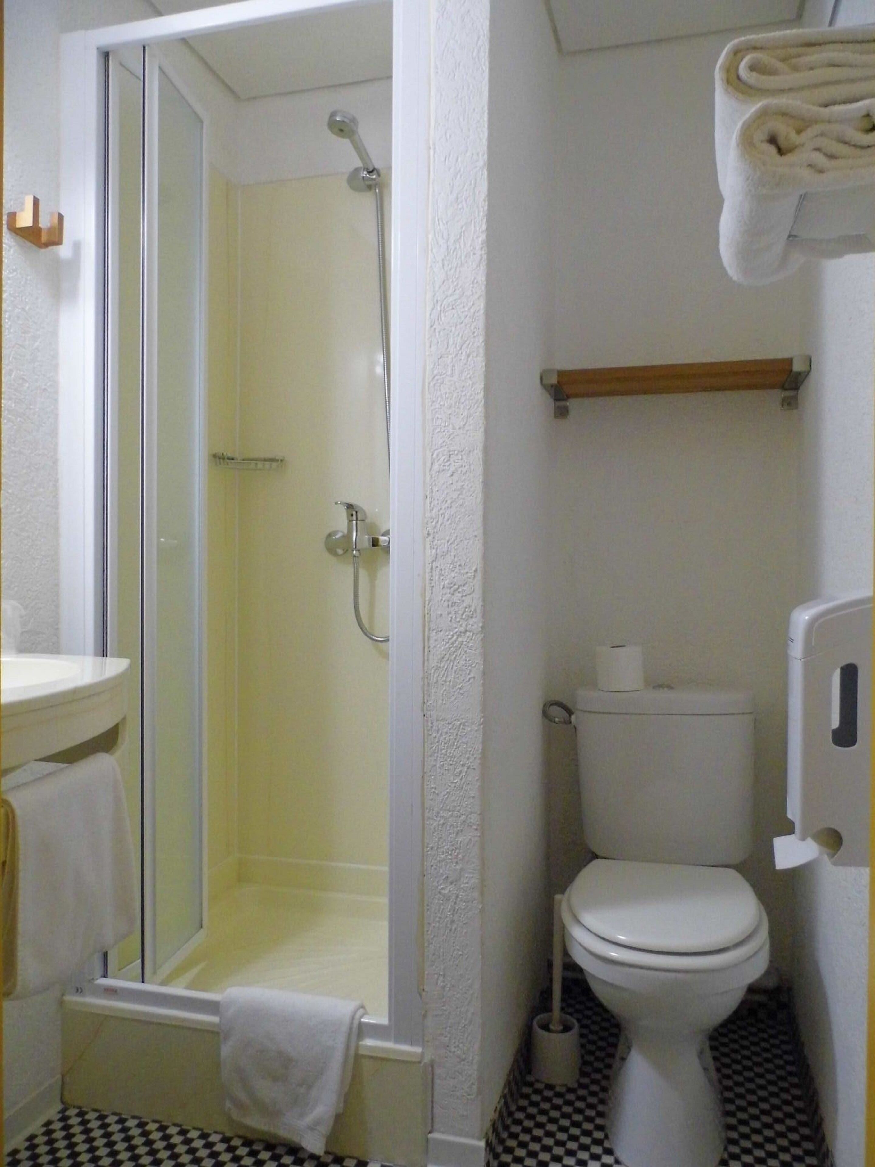 Ein Badezimmer mit Dusche, Toilette und Waschbecken.