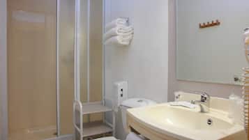 Un baño con ducha, inodoro, lavamanos y barra para toallas.