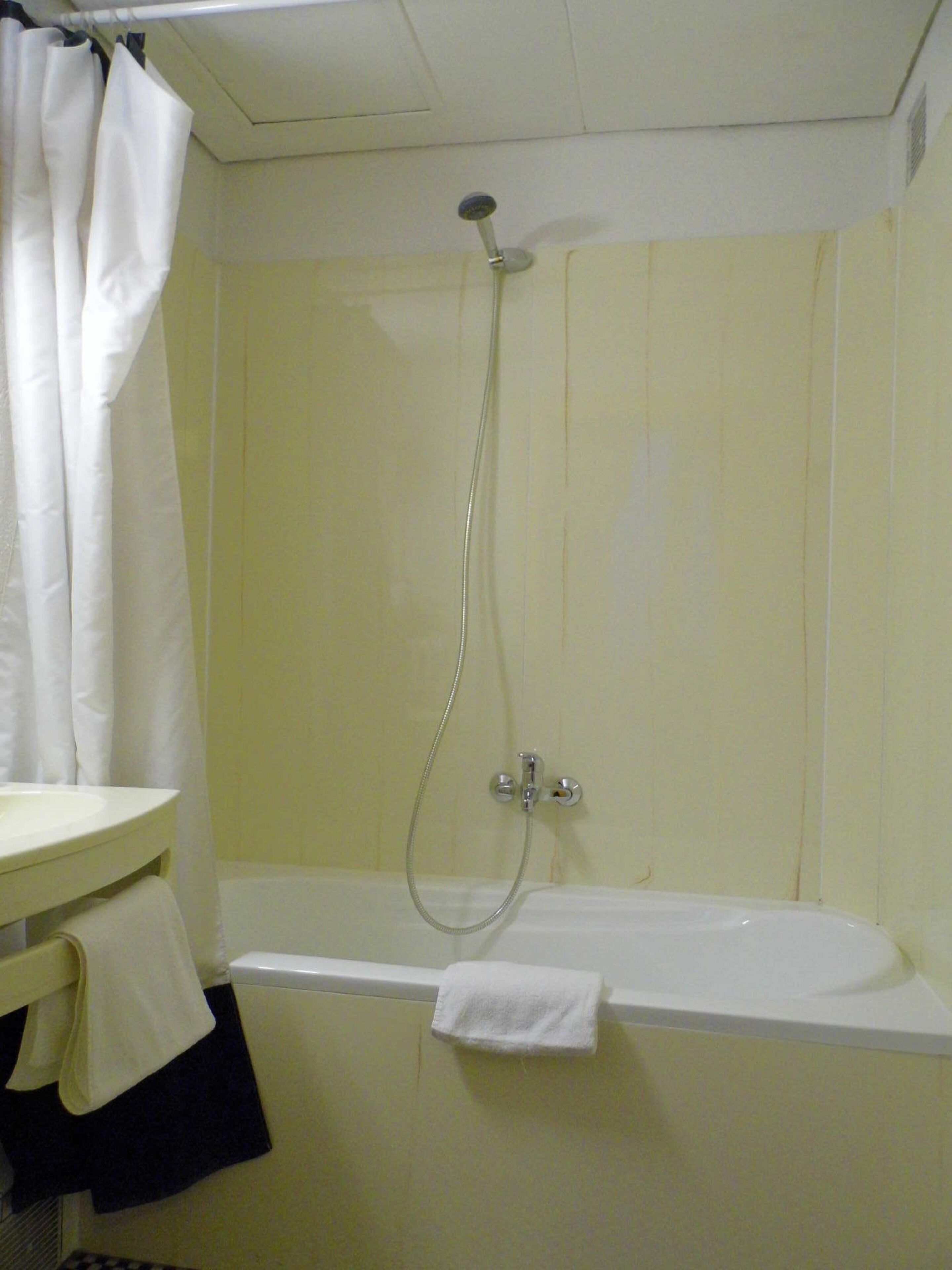A bathroom with a bathtub, a shower, and a sink.