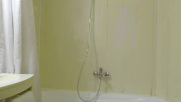 A bathroom with a bathtub, a shower, and a sink.
