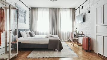 A modern bedroom with a bed, a wardrobe, a desk, a chair, and a suitcase.