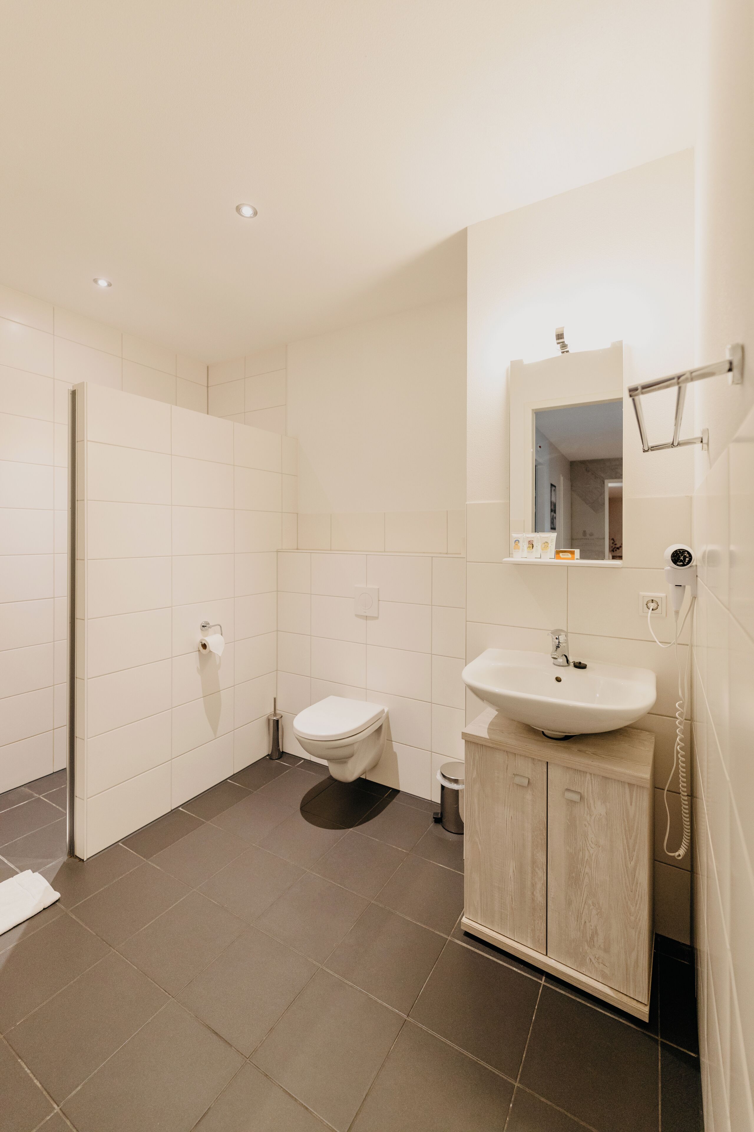 Un baño moderno con inodoro, lavamanos y espejo.