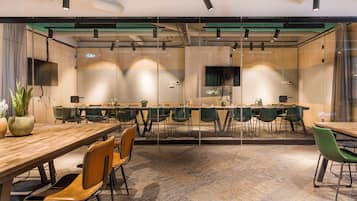 A modern conference room with glass walls, multiple tables, and chairs.