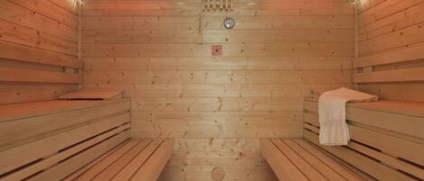 A sauna with wooden walls and benches, two infrared heaters, and a central ventilation system.