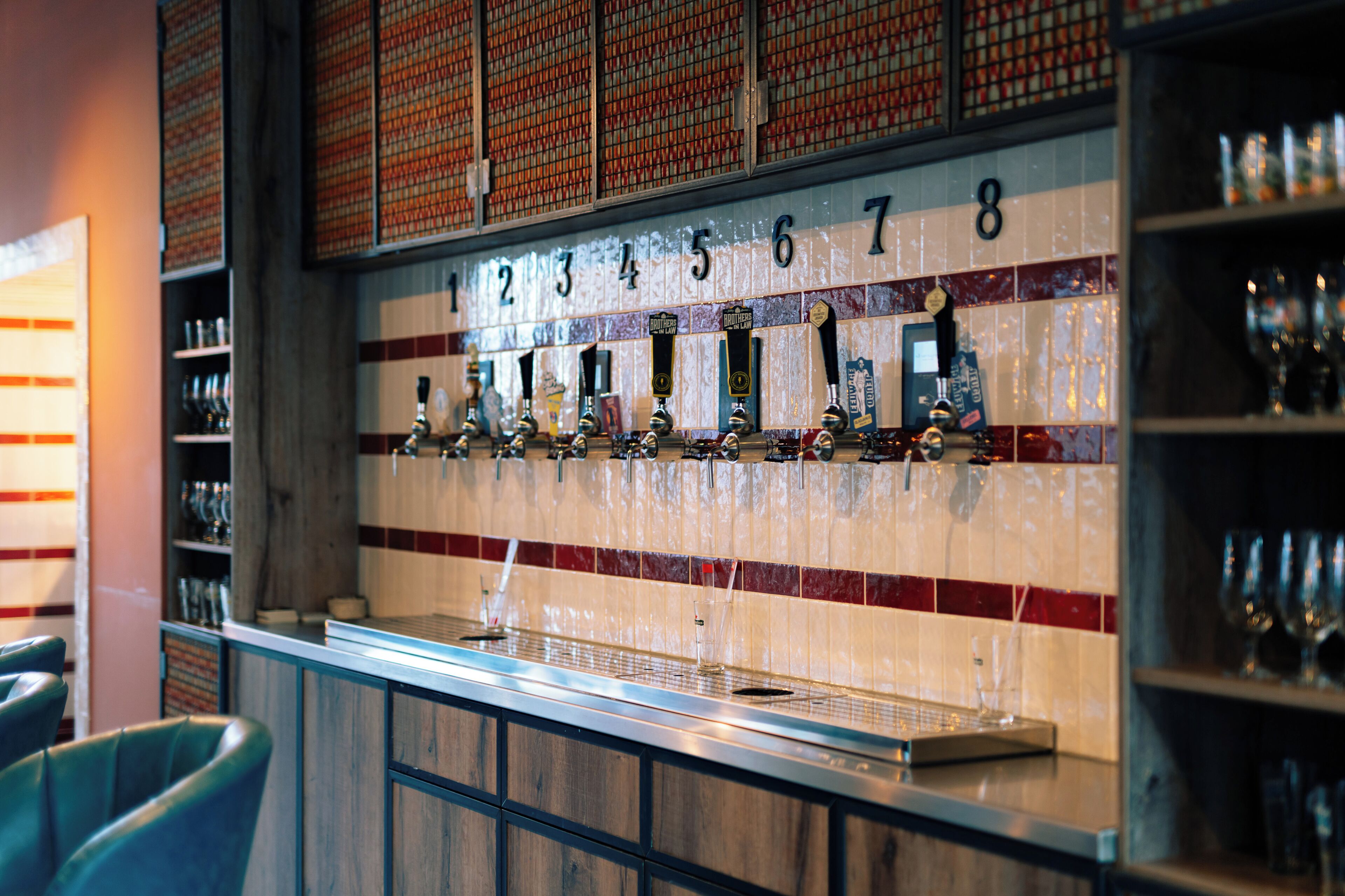 A bar area with numbered taps and shelves of glasses.