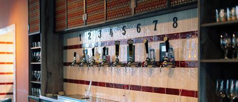 Una zona de bar con grifos numerados y estantes llenos de vasos.