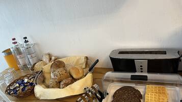 Eine Küchenarbeitsfläche mit verschiedenen Brotsorten, einem Toaster und Gewürzen.