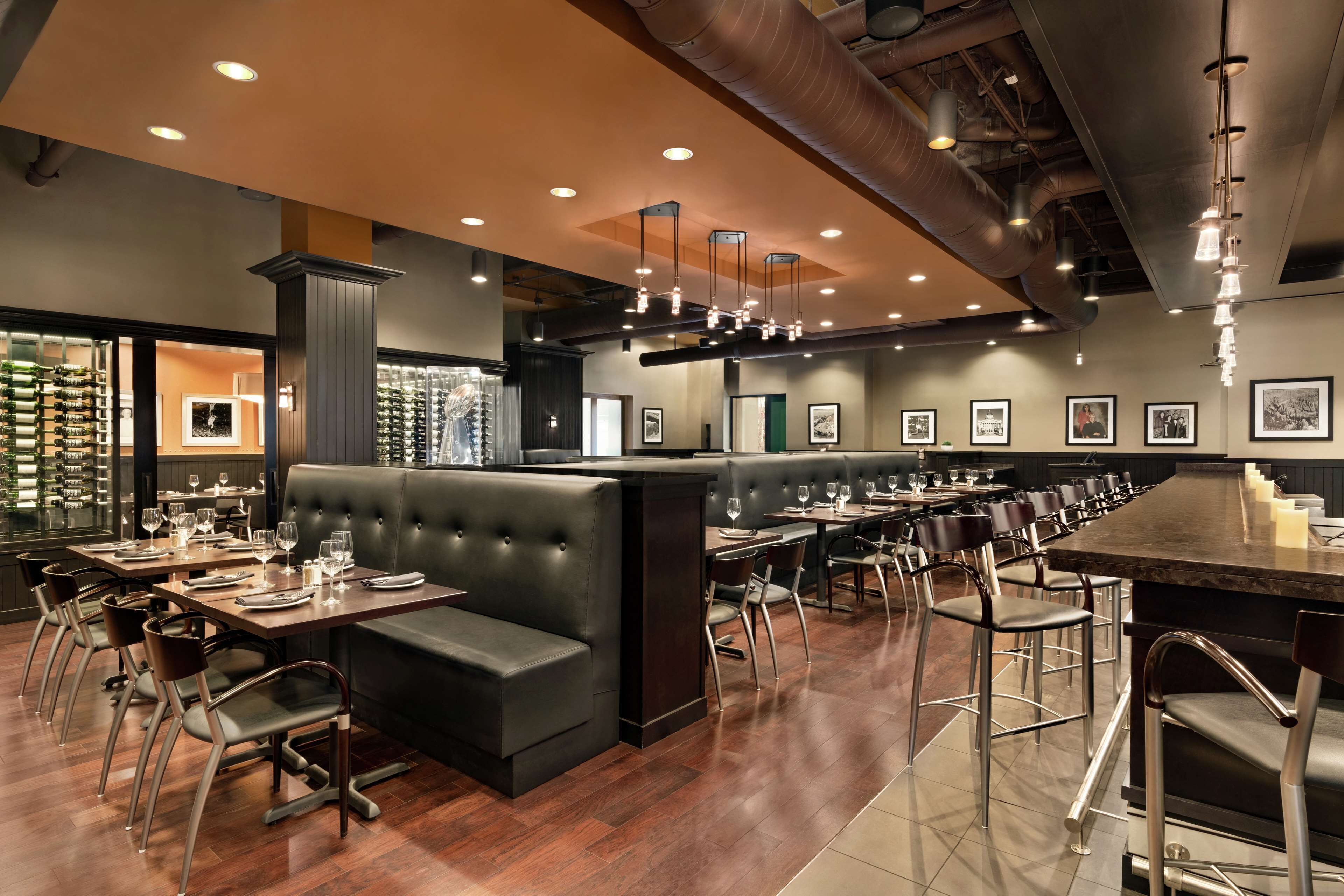 Um restaurante com um balcão extenso, várias áreas de estar e um bar.