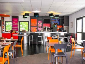 Uma área de bar moderna com balcão, assentos e diversos frascos e copos.