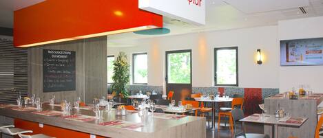 A modern restaurant with a central bar area, multiple tables, and chairs.