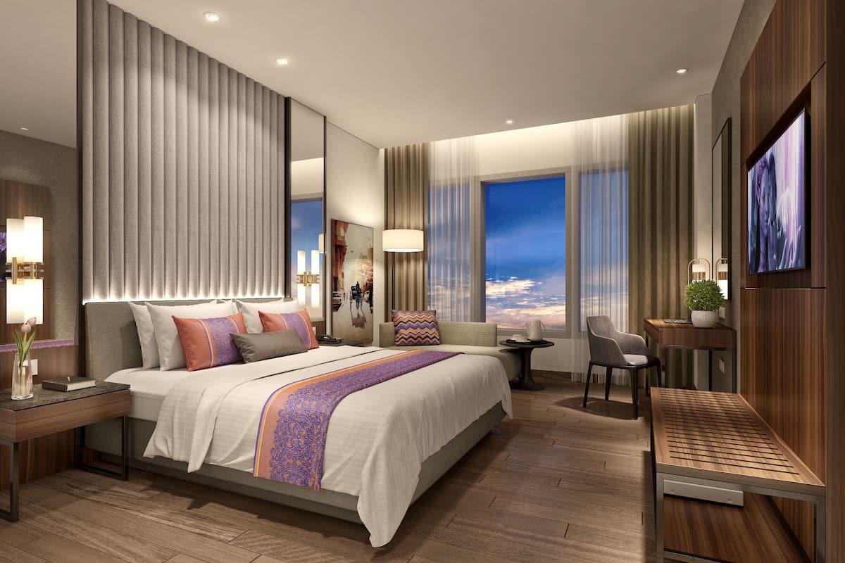 Une chambre d’hôtel moderne équipée d’un grand lit, d’un bureau, d’une chaise et d’un téléviseur.