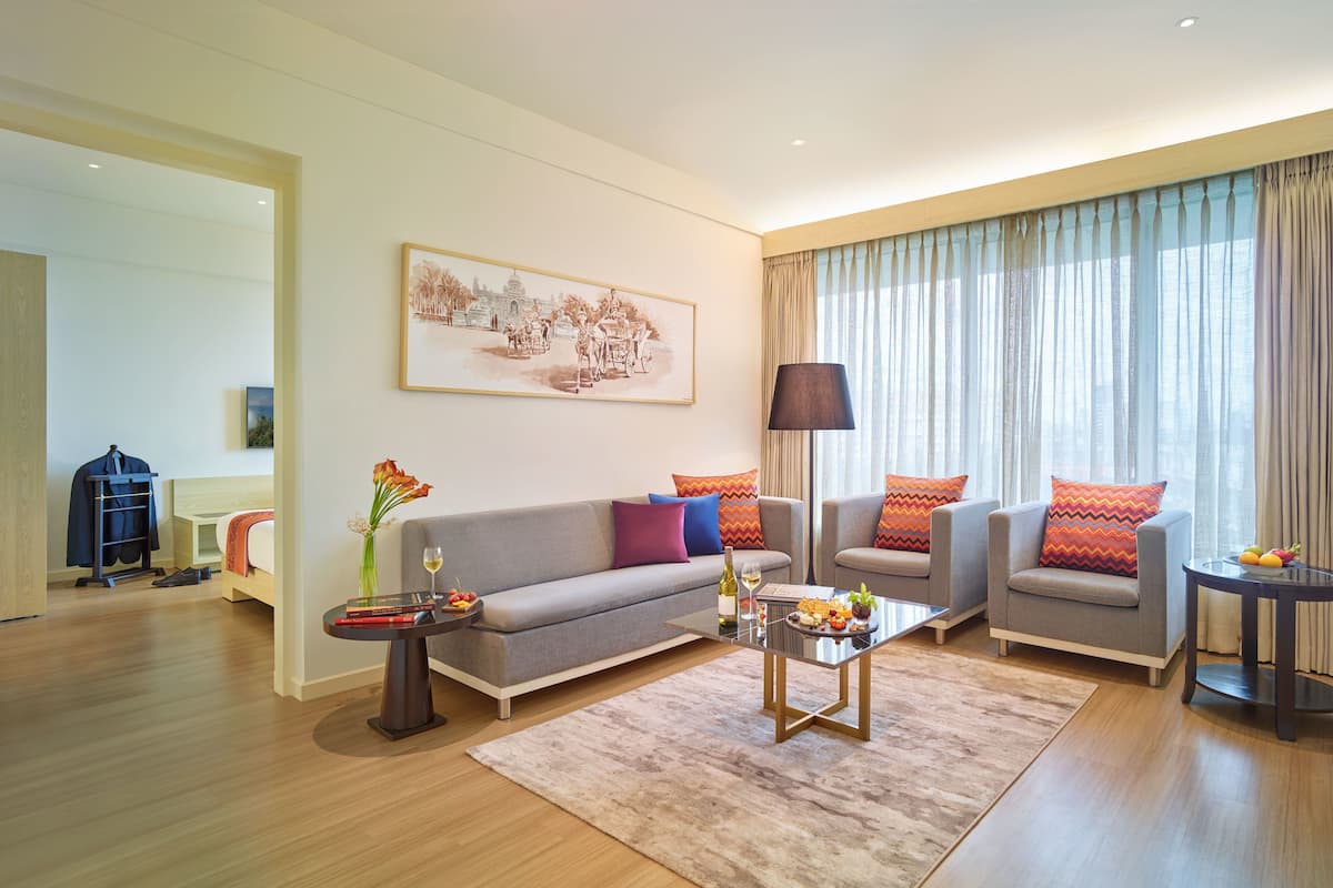 Un salon moderne avec un canapé, des fauteuils, une table basse et un tableau au mur.