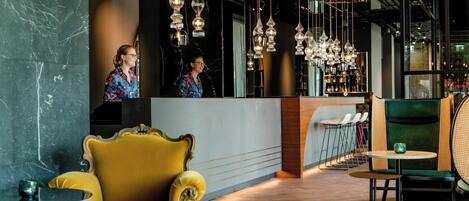 A modern interior with a bar area, seating, and hanging light fixtures.