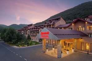 A Marriott hotel with a modern architectural design, featuring multiple balconies and a well-lit entrance area. - Tsaghkadzor Marriott Hotel (Tsaghkadzor)