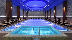 A large indoor swimming pool with lounge chairs and a tiled wall. - Tsaghkadzor Marriott Hotel (Tsaghkadzor)