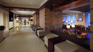 A hotel lobby with a reception desk, seating area, and a fireplace. - Tsaghkadzor Marriott Hotel (Tsaghkadzor)